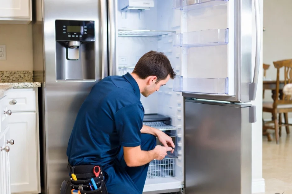 Technician repairing an air conditioner unit in New Delhi workshop.